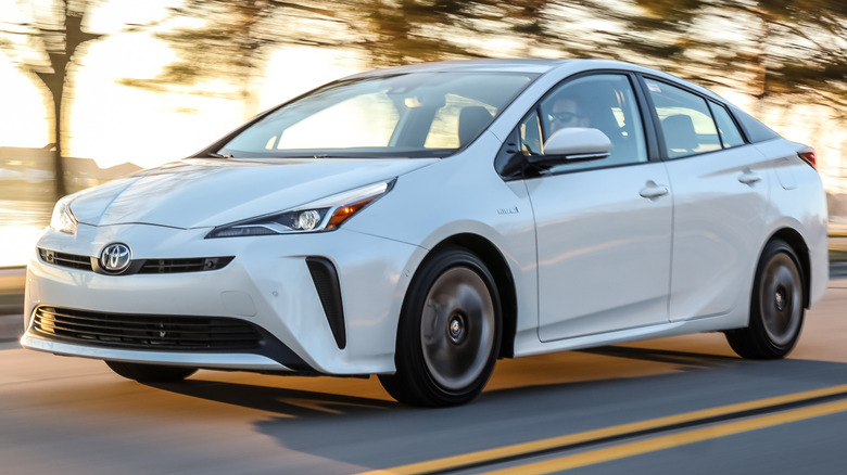 2019 Toyota Prius Limited driving on a paved road next to a body of water