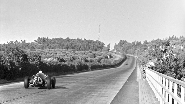 Stirling Moss's Cooper-Climax T51 accelerates down the straight at the 1959 Portuguese Grand Prix.