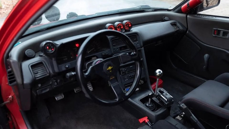 Exterior of a red Honda CRX with gauge pods and a tall shifter