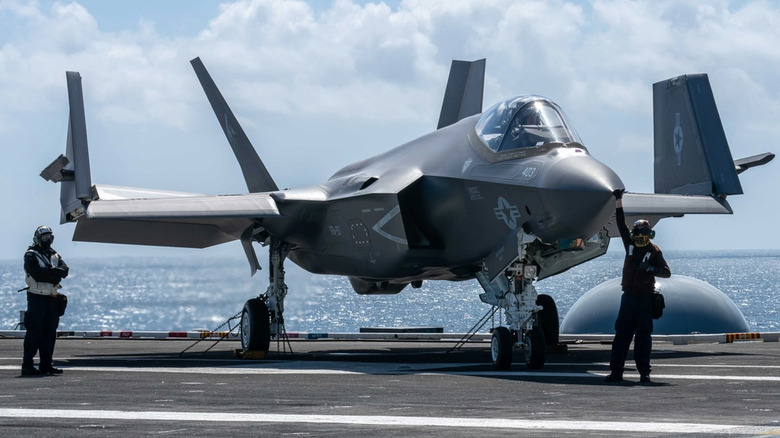 An F-35C tied down with its wings folded on the deck of the USS Carl Vinson