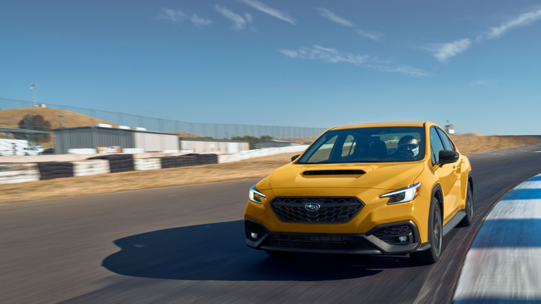 A yellow Subaru WRX on track