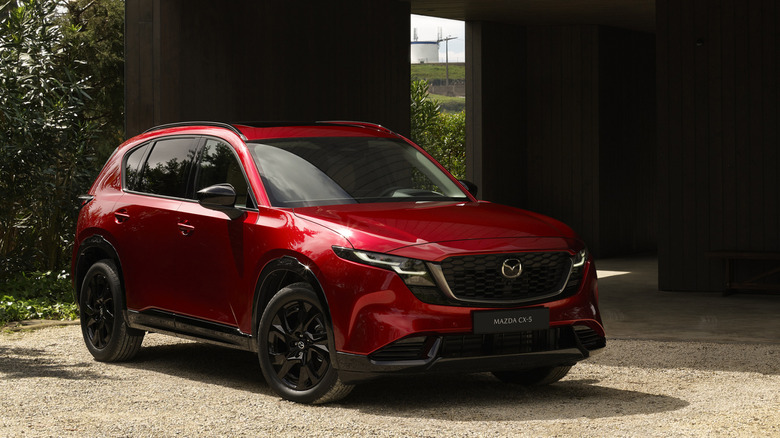 a red Mazda CX-5 parked on a gravel driveway