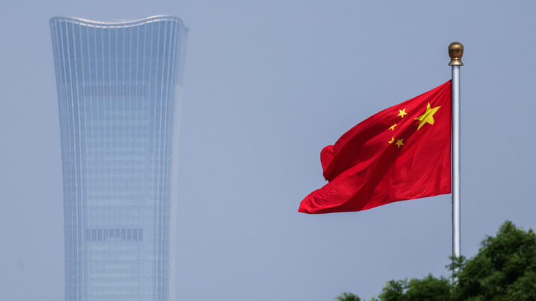 The Citic Tower on a hazy day, with the Chinese flag in the foreground