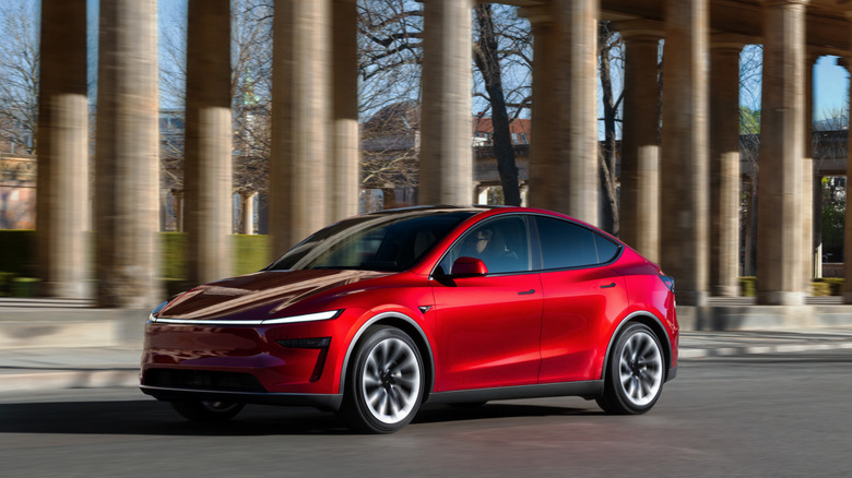 A Tesla Model Y seen on the road in front three-quarter view while driving