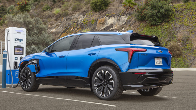 A Chevy Blazer EV seen in rear three-quarter view while charging