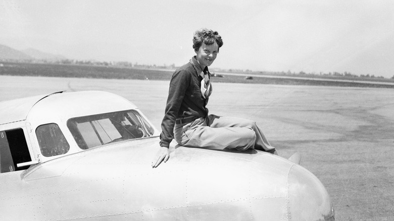 Amelia Earhart sitting on the nose of her Lockheed Electra 10-E