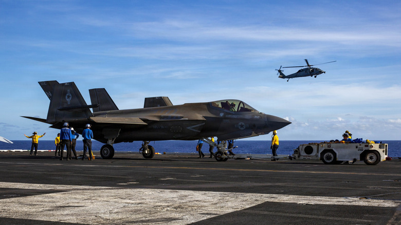 U.S. Navy Sailors taxi an F-35C Lightning II, attached to Marine Fighter Attack Squadron (VMFA) 314, on the flight deck of Nimitz-class aircraft carrier USS Abraham Lincoln