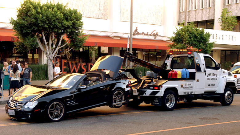 A black Mercedes-Benz driven by actress Lindsay Lohan is taken away by a tow truck after the actress collided with a van on Robertson Boulevard in West Hollywood, California on Tuesday, October 4, 2005. Lohan and a female passenger in her car suffered min