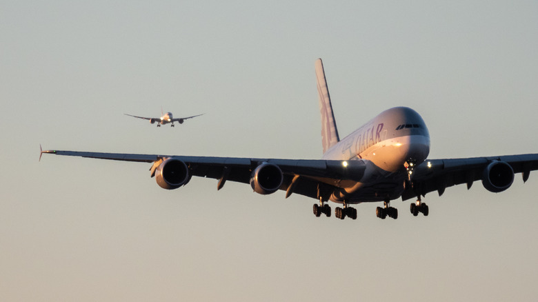 A Qatar Airways Airbust A380 comes in for a landing, with a Qantas Boeing 787 just behind