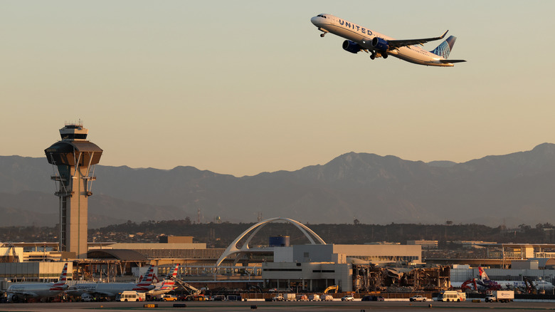 A United Airlines Airbus A321 takes off from Los Angeles International Airport near the air traffic control tower