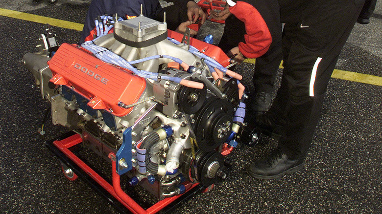 Technicians inspecting a Dodge racing crate engine ready to be fitted to a race car