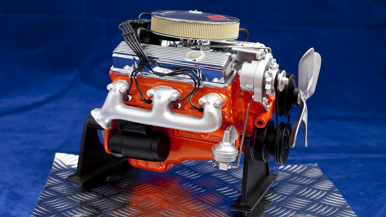 A Chevy 350 Small Block V8 crate engine on a stand with a blue background