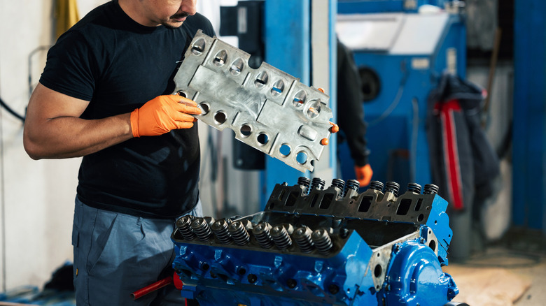 A technician working on a V8 engine block