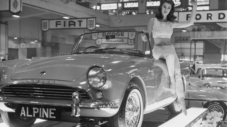 A woman posing on a Sunbeam Alpine sports car