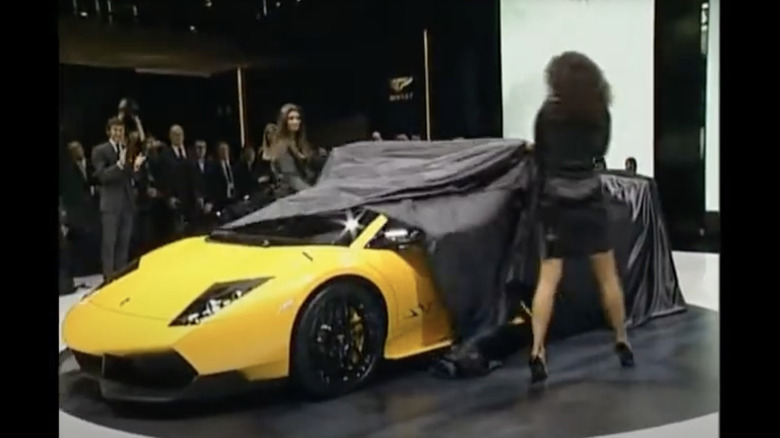 A yellow Lamborghini Murcielago getting revealed at an auto show