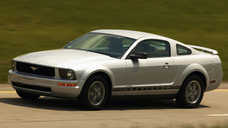 a ford mustang driving down a road