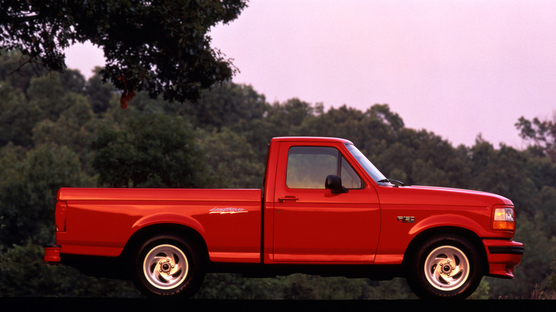 A 1994 Ford F-150 Lightning parked in front of some trees on a summer's evening