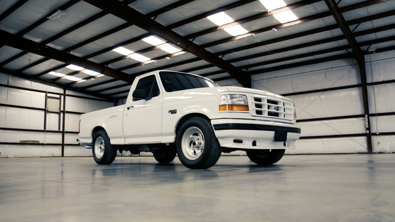 A white F-150 Lightning parked in a warehouse