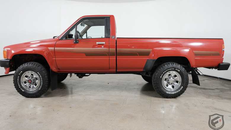 Red 1986 Toyota Pickup Truck in a room with blank white walls