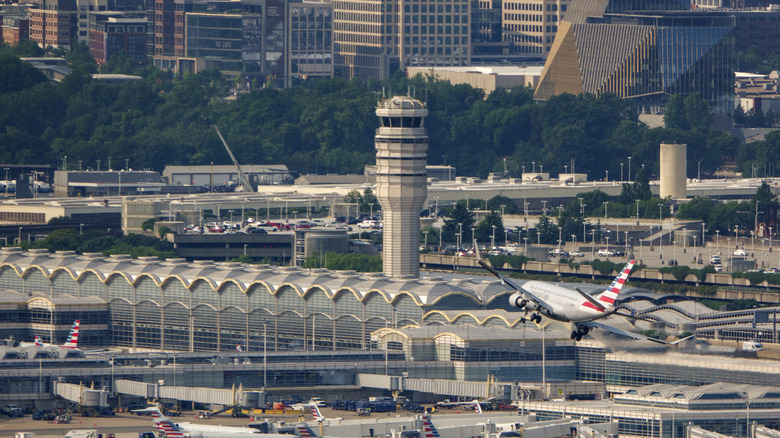 An airplane flies towards the runway near the air control tower of the Ronald Reagan Washington National Airport.