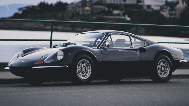 A black Ferrari Dino 246 GT parked by the ocean
