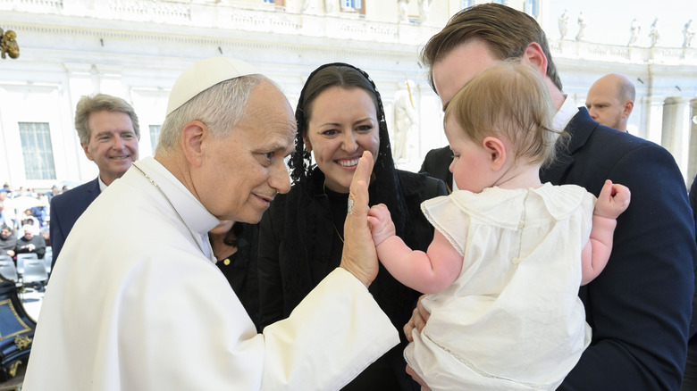 Pope Leo high-fives a baby