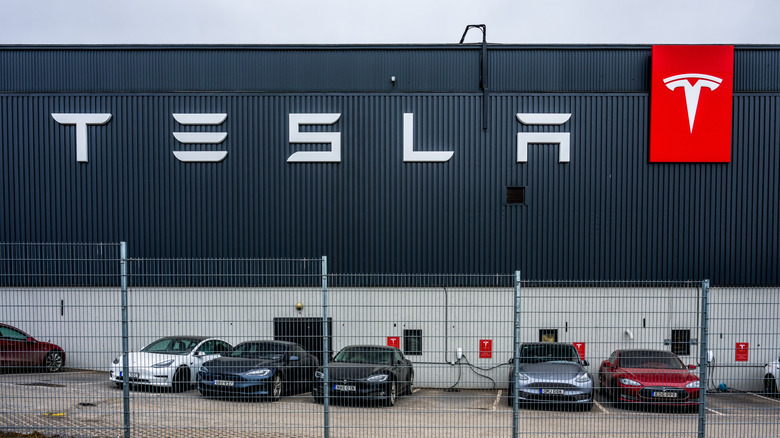 Stockholm, Sweden - March 09 2024: tesla facility with branded signage and charging electric vehicles