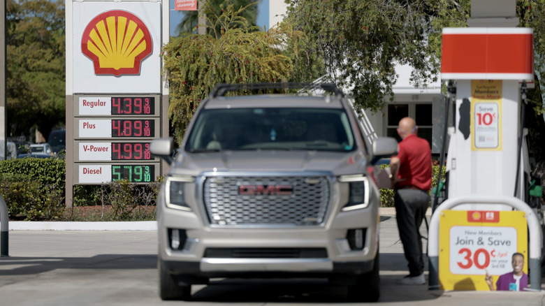 Fuel prices are displayed on a sign as a customer fills their vehicle at a gas station on April 13, 2026 in Miami, Florida.