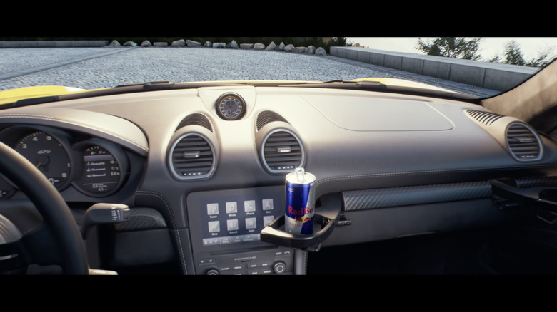 A can of Red Bull sitting in the cupholder inside a Porsche Cayman GT4.