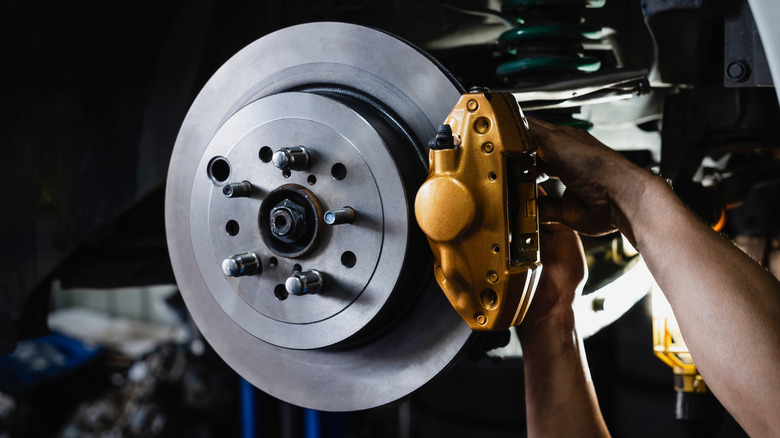 A tight shot of a mechanic working on a modern disc brake setup.