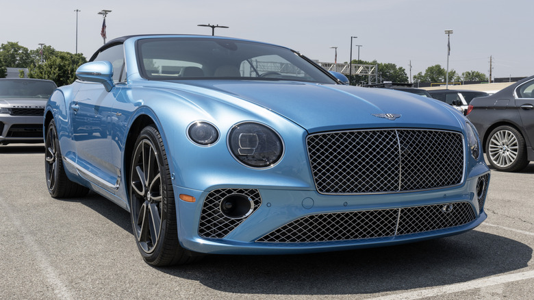A blue Bentley Continetal GTC parked in an outdoor parking lot.