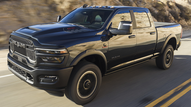 A black 2025 Ram 2500 Heavy Duty Rebel driving on a desert road