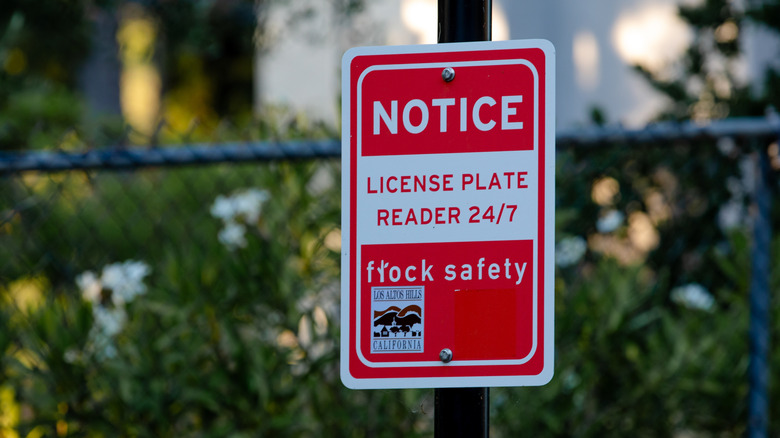Los Altos Hills, CA US - June 14, 2025: a red and white sign for Automatic License Plate Reader (ALPR) system by Flock Safety operating in Los Altos Hills, CA, to help deter and solve crimes