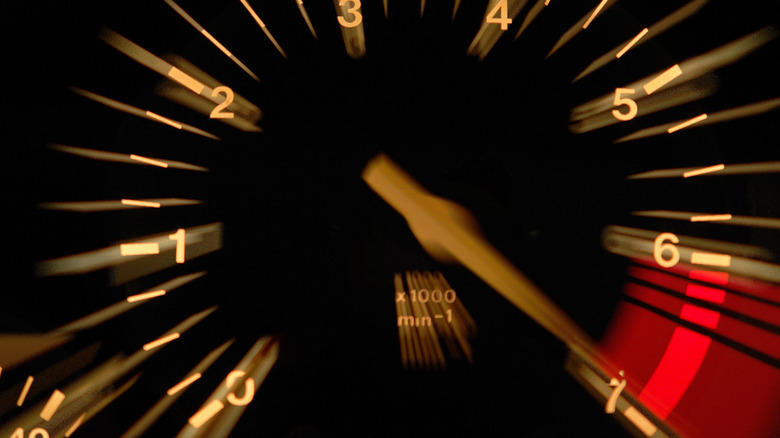 blurry photo of a tachometer redlining at 7,000 RPM at night