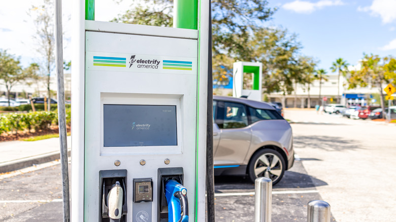 Electrify America EV electric vehicle charger station for charging cars in Florida shopping mall with parked transportation trucks