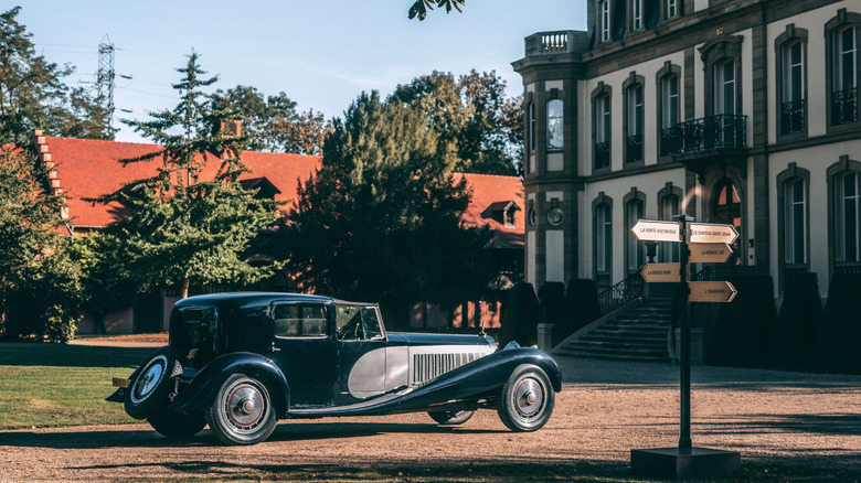 A Bugatti Type 41 Royale near a sign