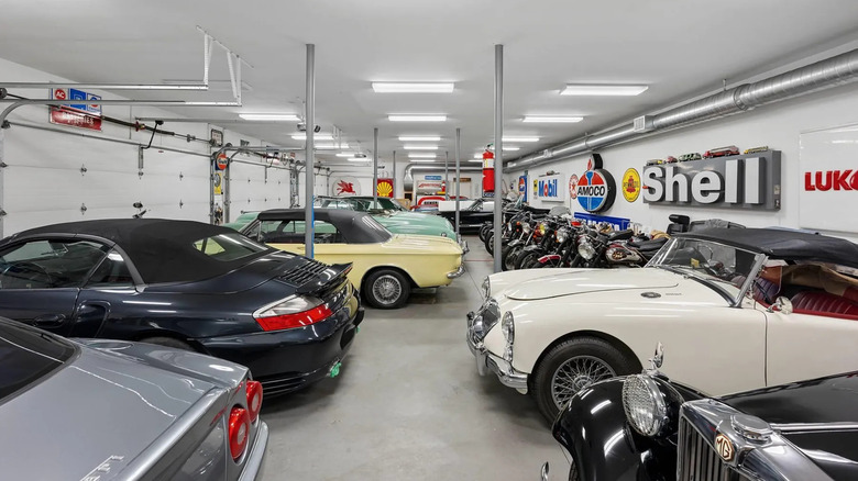A peek into one of the garage areas where a line of motorcycles, memorabilia, a Porsche and a Ferrari are stored.