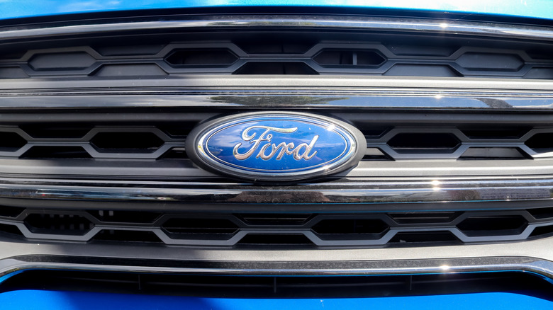 Close up of a Ford logo infront of a car
