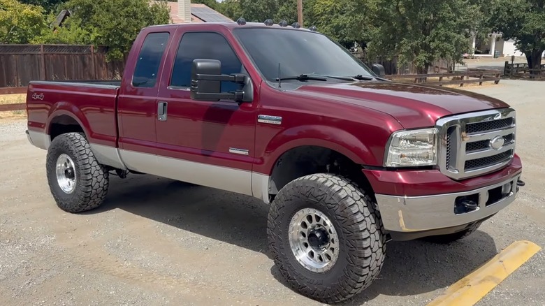 A red 2005 Ford F-250 with a 6.0 Power Stroke parked in an empty parking lot