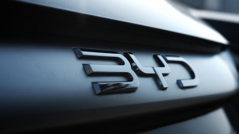 Close-up of a metallic 'BYD' emblem on the dark rear of a modern car, highlighting the sleek numbers and automotive detail. Photo taken in Cigombong, West Java, Indonesia in 07 Jun 2025