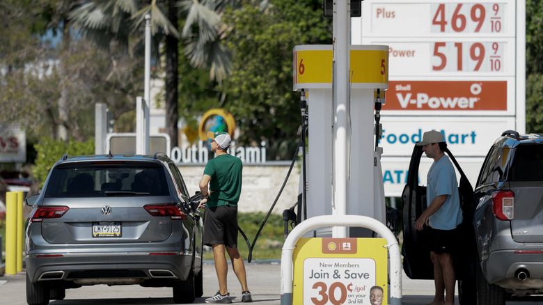 Fuel prices are displayed on a sign as customers fill their vehicles at a gas station on April 13, 2026 in Miami, Florida.
