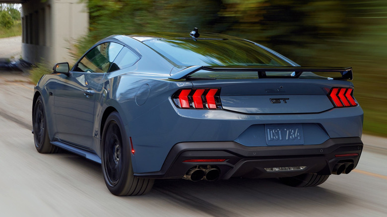 A 2026 Ford Mustang GT Premium fastback, seen from the rear at speed on a highway