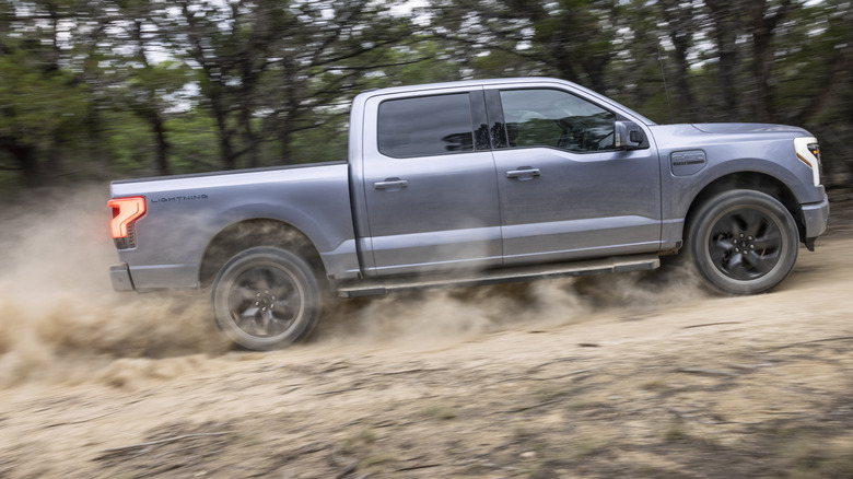 A gray F150 Lightning drives offroad