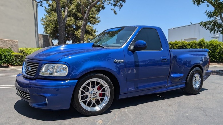 A Blue 2004 Ford F150 Lightning parked outside in the sun