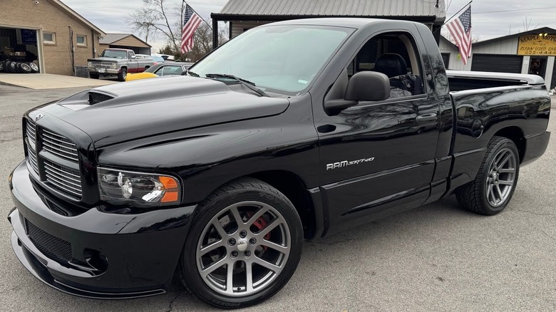A black 2004 Ram SRT-10 parked on a paved surface with buildings and other vehicles in the background