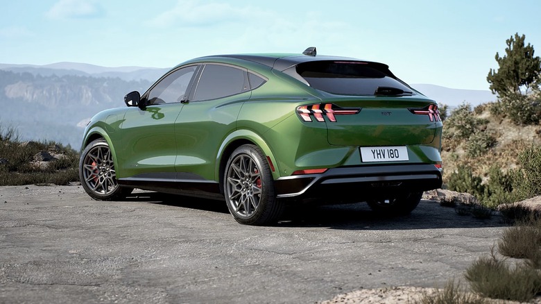 A 2025 Mustang Mach-E in green with a mountain range in the distance