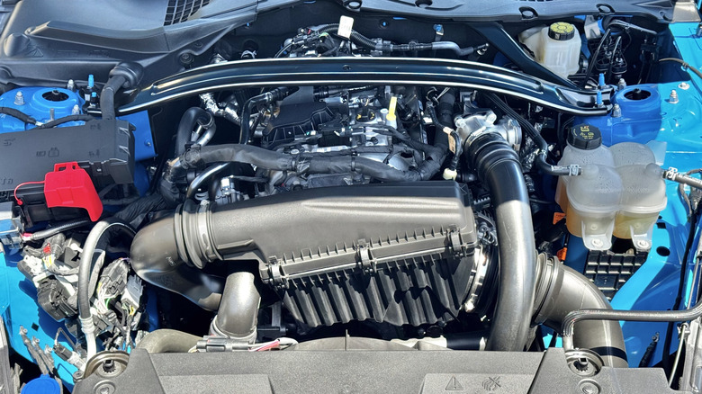 A photo looking under the hood of the blue Mustang showing the EcoBoost four-cylinder engine