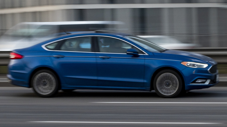 A blue Ford Fusion driving on a highway