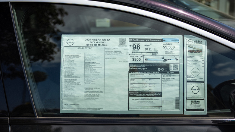 TORRANCE, CALIFORNIA - APRIL 3: The Monroney label, or window sticker, for a 2025 Nissan Ariya Evolve, with a final price of $47,115, at the Nissan of Torrance auto dealership, selling Honda cars, trucks and SUVs, on April 3, 2025 in Torrance, California. Car dealers are bracing for the effects of President Trump's newly imposed tariffs, saying the increases that will be attached to new foreign car imports and parts will likely be passed onto consumers, creating greater demand for used cars, that will not have tariff-pricing.