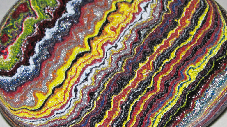 A closeup of a cross section of Fordite, displaying an array of different colors.